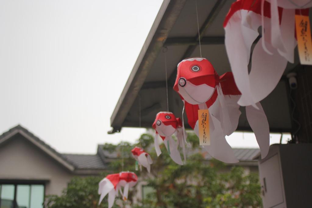 un groupe de poulets en papier suspendus à un bâtiment dans l'établissement 梨幸日和 Good Days in Liko, à Kang-shan
