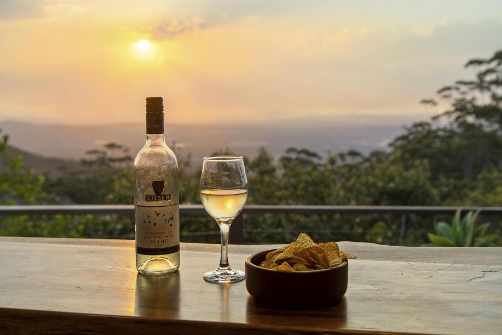 a bottle of wine and a glass on a table at The Bird House in Mount Tamborine