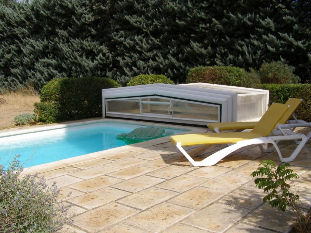 una piscina con una silla y un calentador en Maison provençale chaleureuse avec piscine en Mouriès