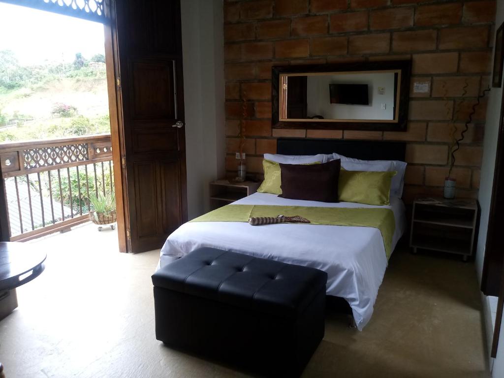 1 dormitorio con 1 cama grande y balcón en Hotel Casa Lily en El Carmen de Atrato