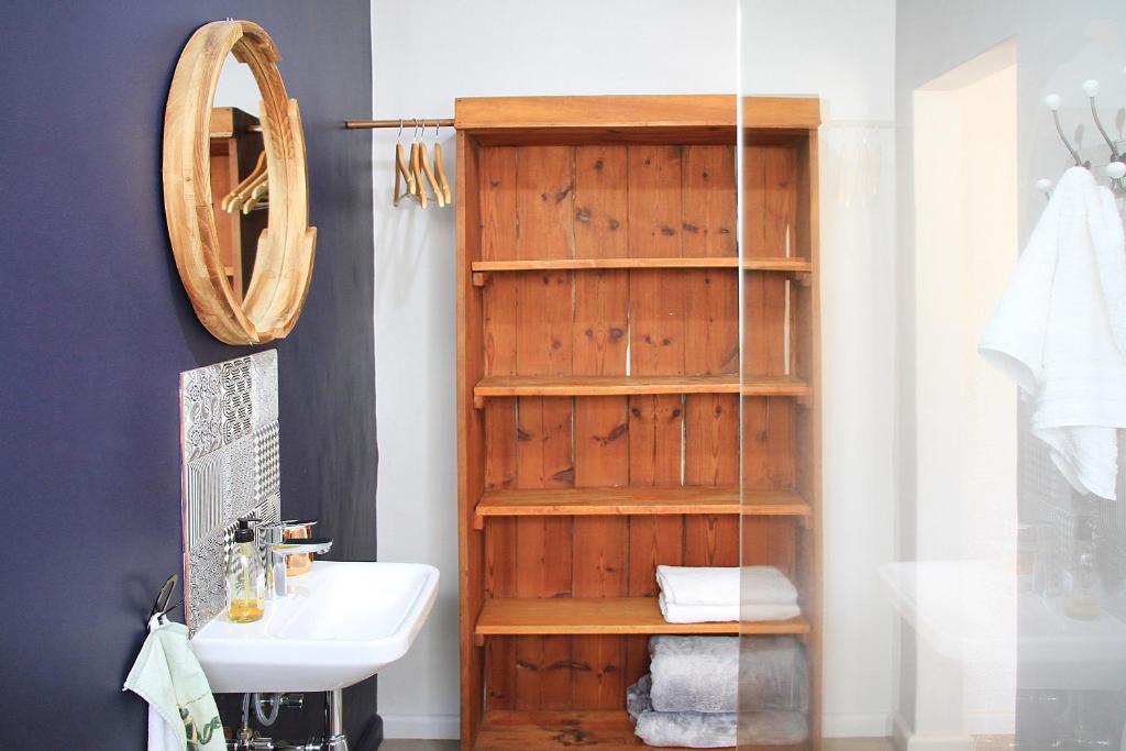 un bagno con porta in legno accanto a un lavandino di Olive tree private rooms in Stellenbosch- No Load Shedding a Stellenbosch