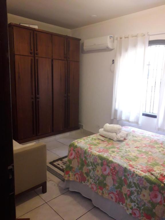 een slaapkamer met een bed en een dressoir en een bed bij Hospedagem domiciliar in Guarujá