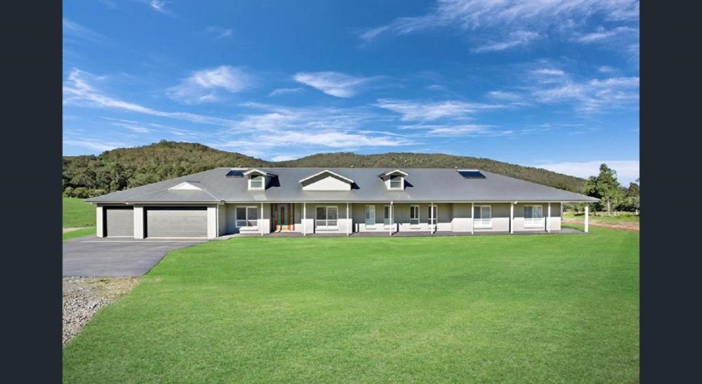 a large house with a green lawn in front of it at ON Keppies - BnB - Family Farm & Wedding Guest Accommodation Paterson NSW in Paterson