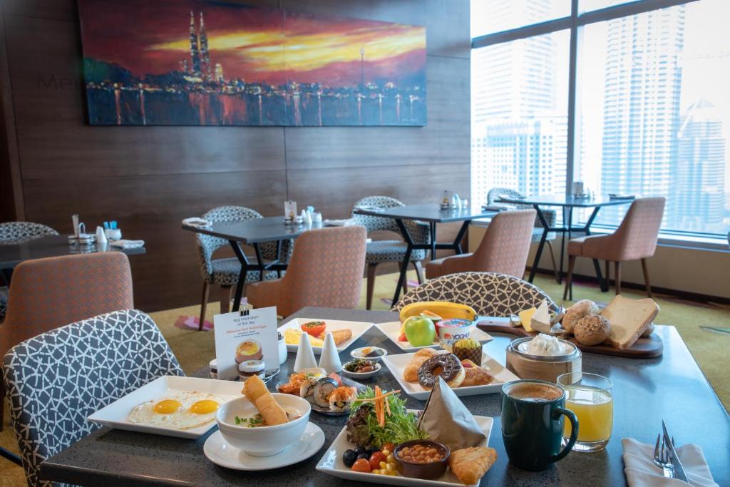A generously laid breakfast table sits beside windows overlooking the skyline.