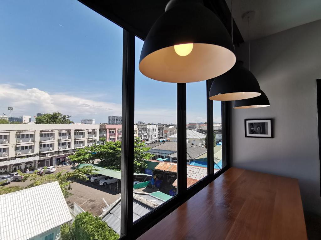 a room with a large window with a view of a city at The Besavana Phuket - SHA Extra Plus in Phuket Town