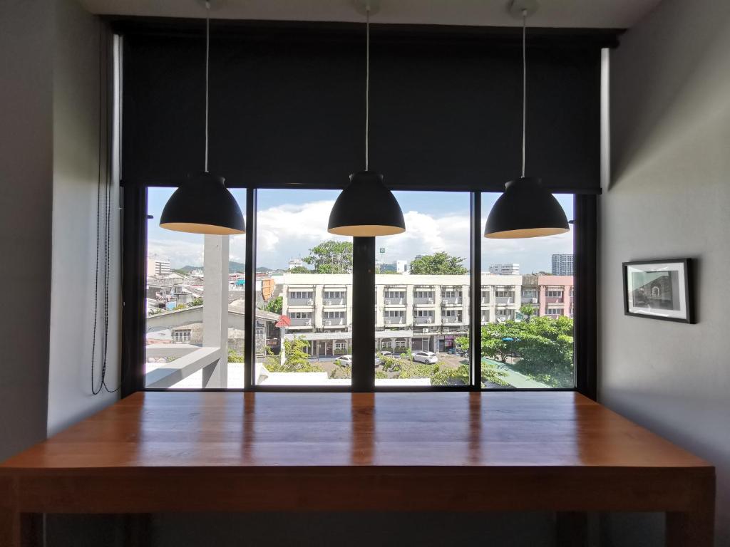 a dining room with a table and a large window at The Besavana Phuket - SHA Extra Plus in Phuket Town