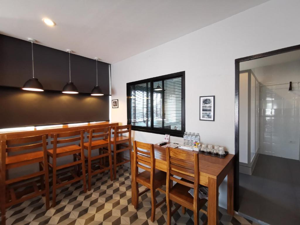 a dining room with a bar with wooden chairs at The Besavana Phuket - SHA Extra Plus in Phuket Town