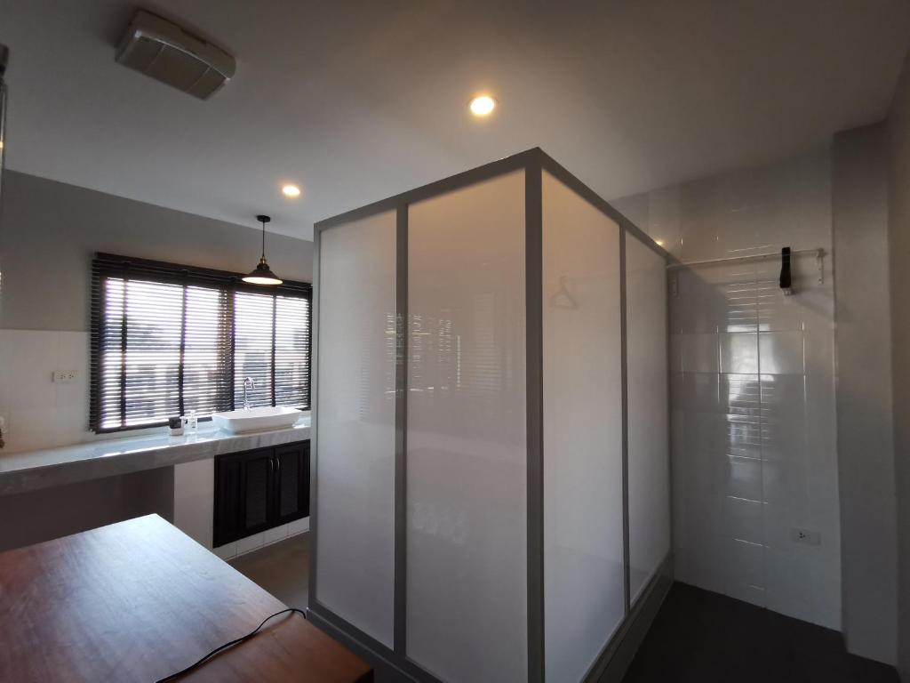 a bathroom with a glass shower and a sink at The Besavana Phuket - SHA Extra Plus in Phuket Town
