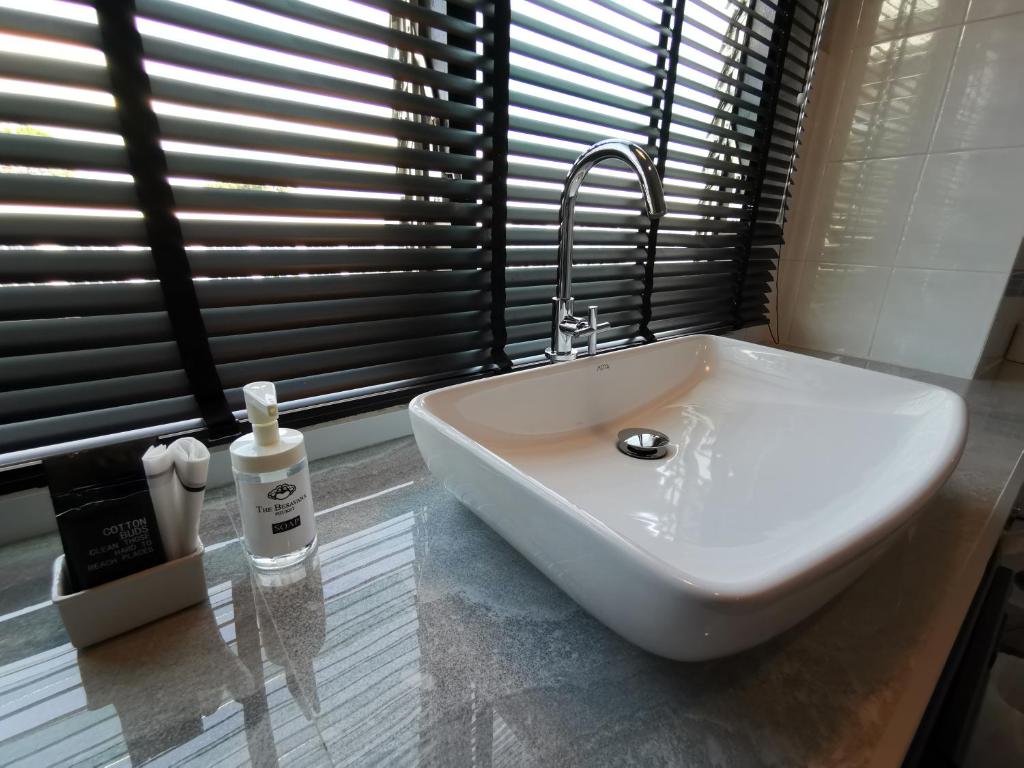 a white sink with a faucet in a bathroom at The Besavana Phuket - SHA Extra Plus in Phuket Town