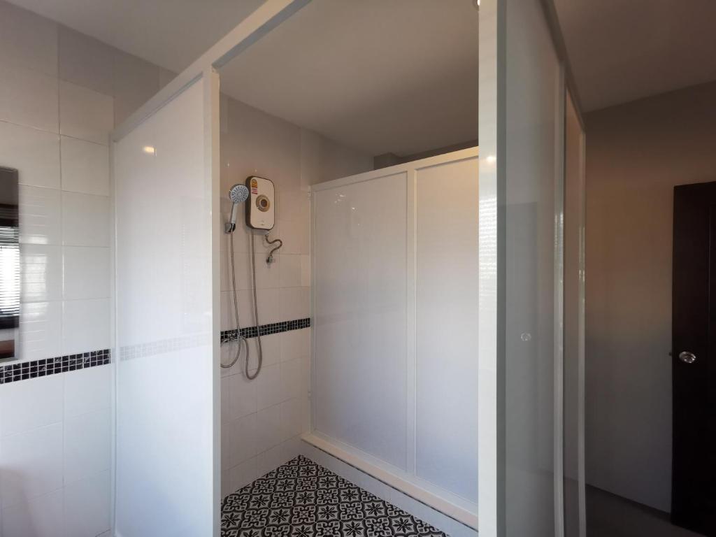 a bathroom with a shower with a phone on the wall at The Besavana Phuket - SHA Extra Plus in Phuket Town