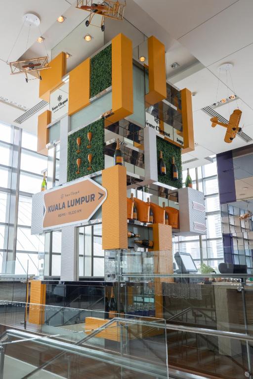 A bright lobby installation celebrates Kuala Lumpur with a prominent cultural umbrella sign.