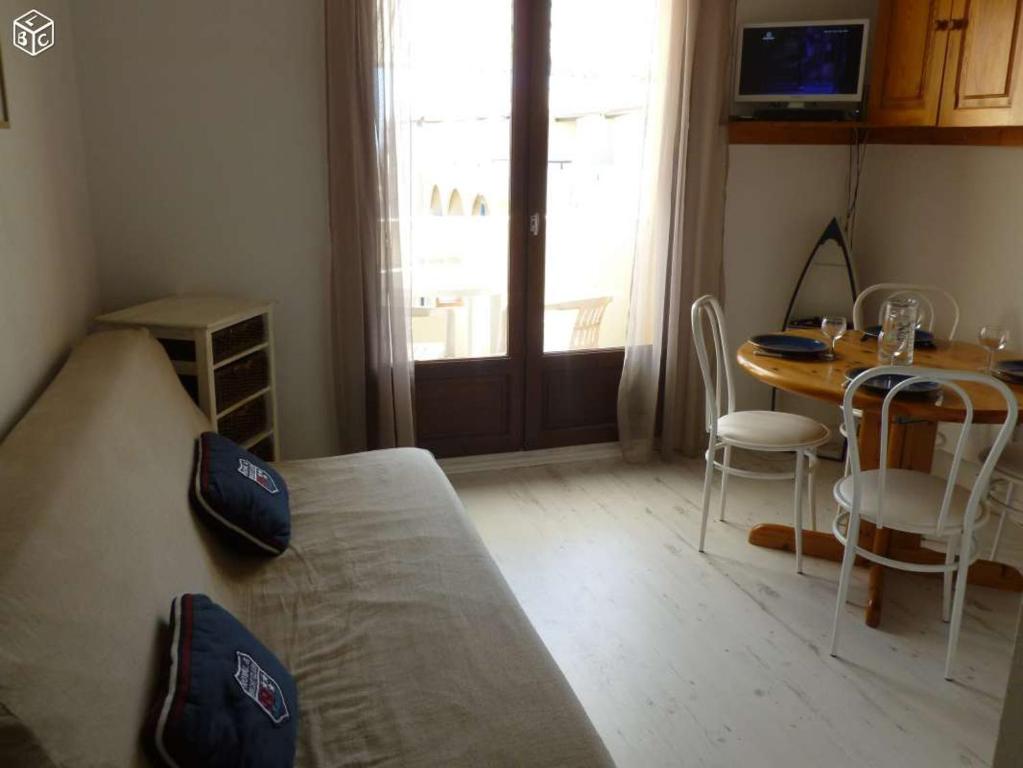 a small room with a bed and a table and a window at Coquet appartement in Fleury