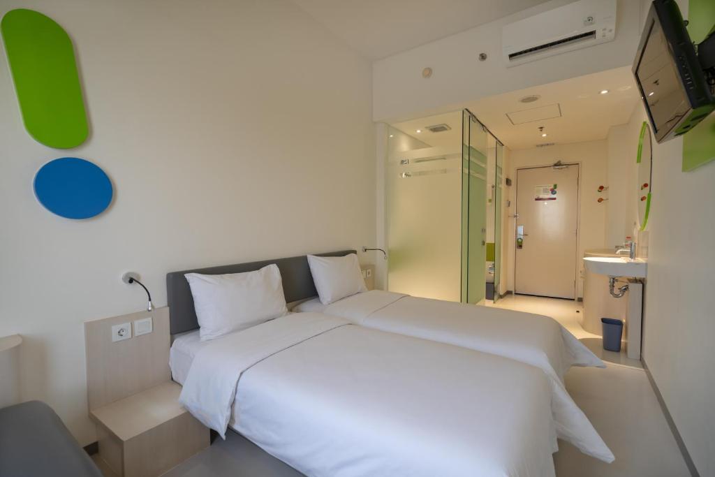 a bedroom with a white bed and a bathroom at POP! Hotel Festival Citylink in Bandung