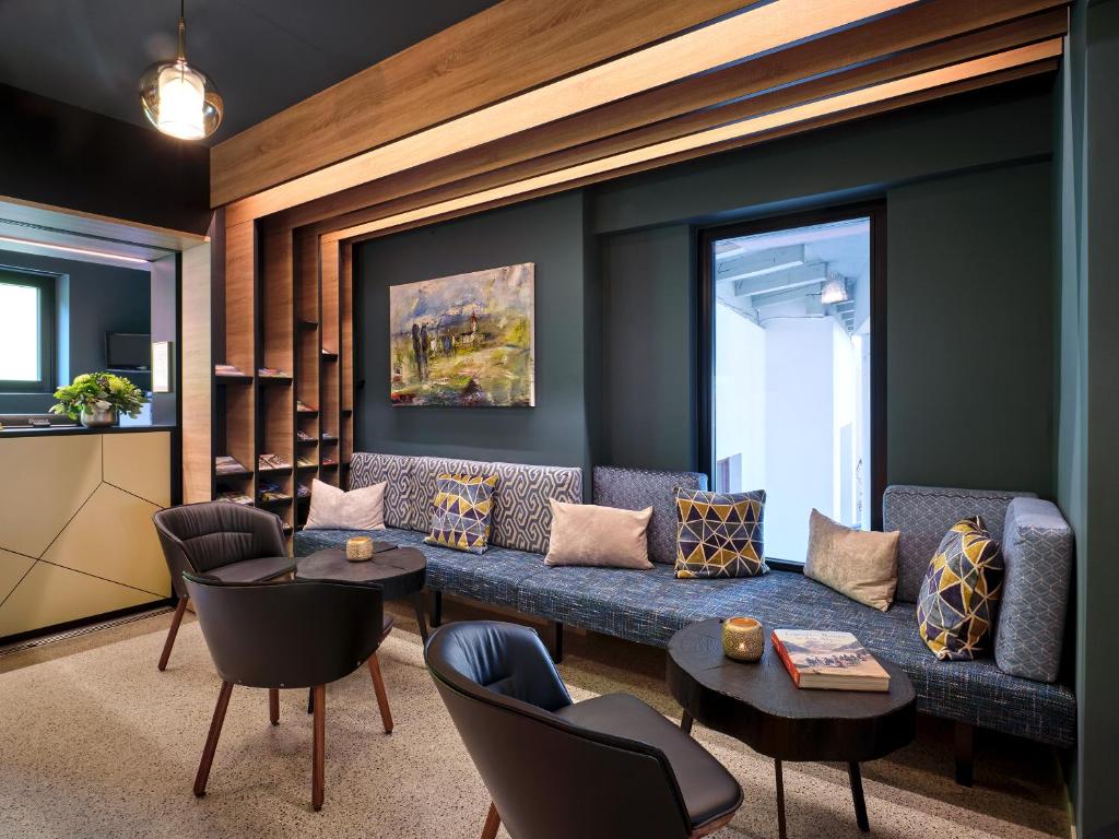 聖安東阿爾貝格的住宿－Quality Hosts Arlberg - Hotel Goldenes Kreuz B&B，客厅配有蓝色的沙发和椅子