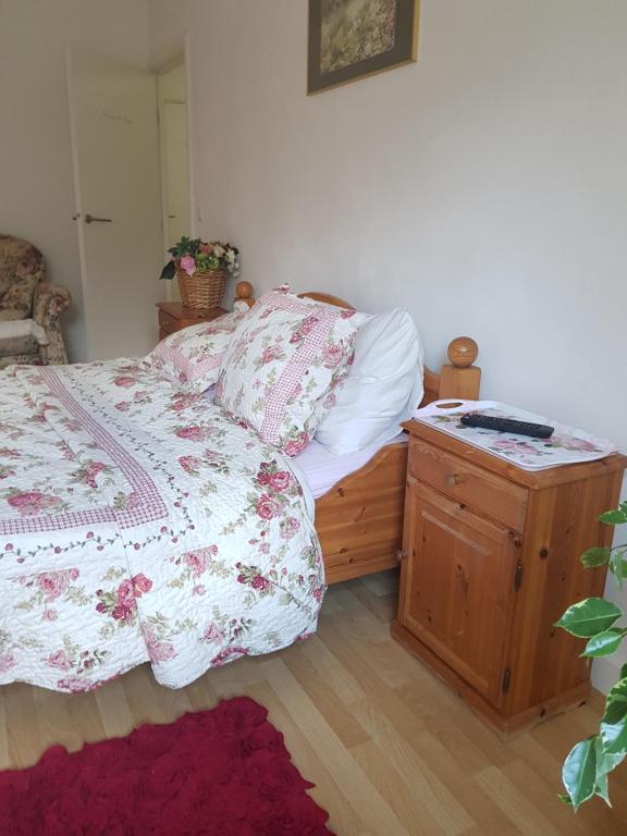 een slaapkamer met een bed en een houten nachtkastje bij Little Amsterdam in Uithoorn