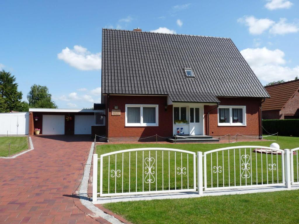 a white fence in front of a house at Ferienwohnung Kleinhaus, 95008 in Rhauderfehn