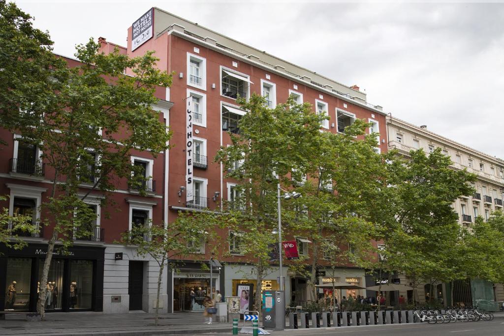un edificio de ladrillo rojo en una calle de la ciudad con árboles en ICON Embassy en Madrid