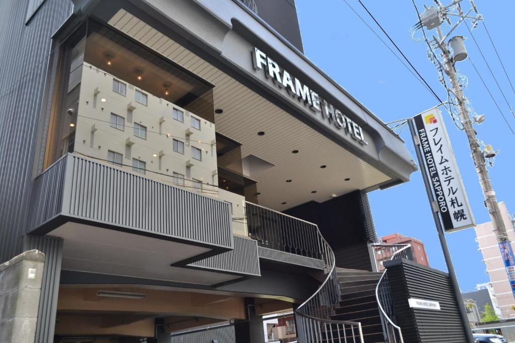 a building with a sign on the side of it at Frame Hotel Sapporo in Sapporo