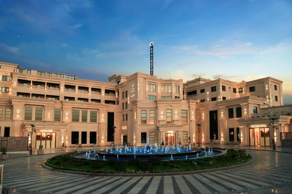 a large building with a fountain in front of it at Opal Hotel Amman in Amman