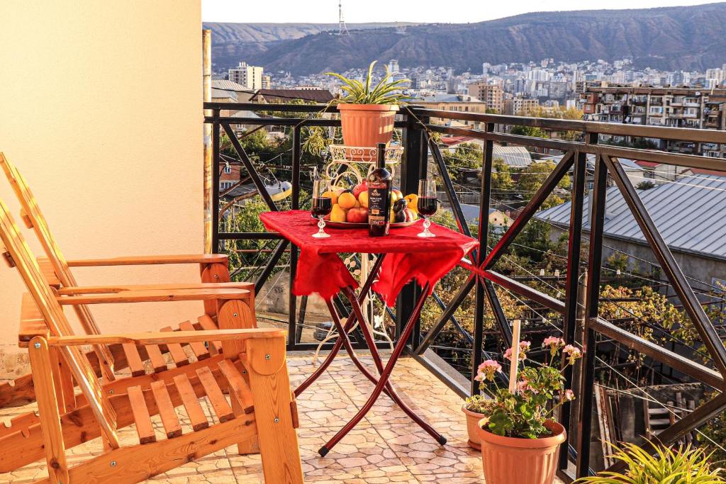 una mesa con fruta en el balcón en Gamarjoba Hotel en Tiflis