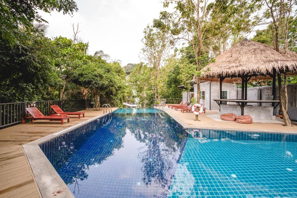 a swimming pool with chairs and a gazebo at The Dearly Koh Tao Hostel-PADI 5 Star Dive Resort in Ko Tao