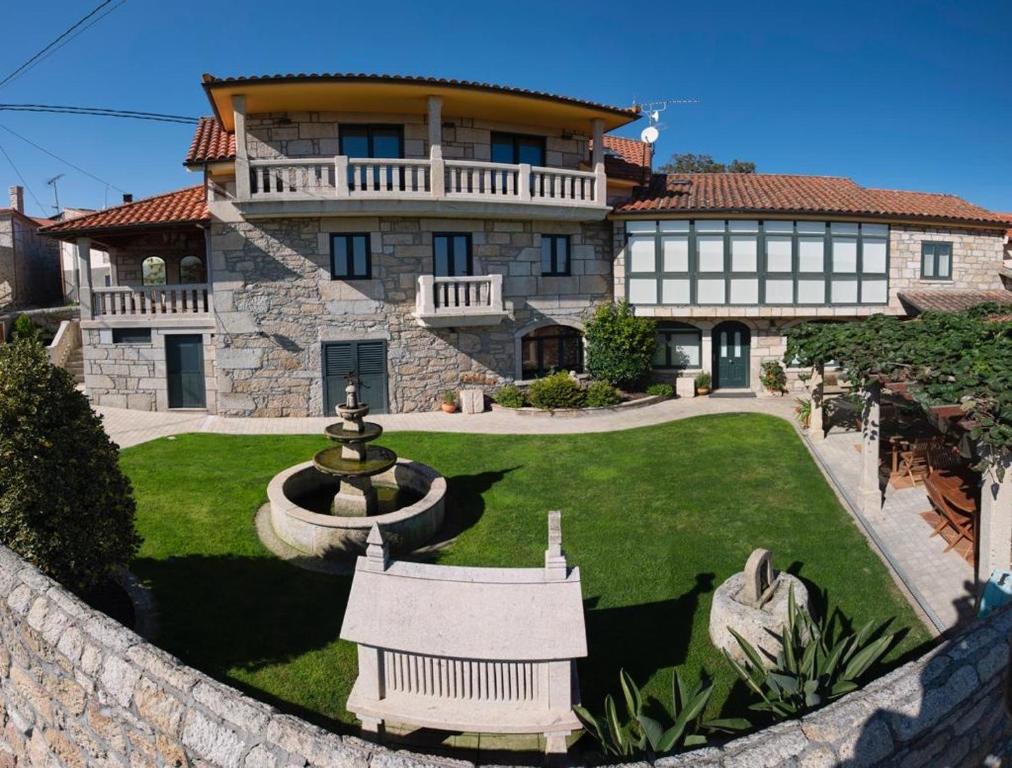 a large house with a fountain in the yard at Apartamentos Río Sil in Sober