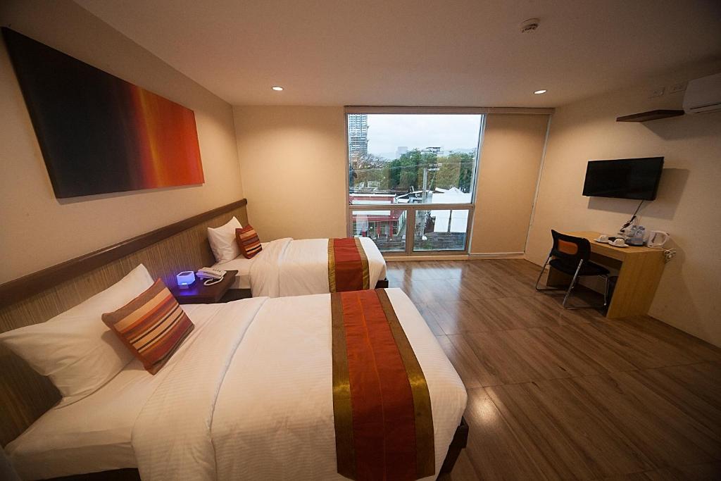 a hotel room with two beds and a television at NS Royal Hotel in Cebu City