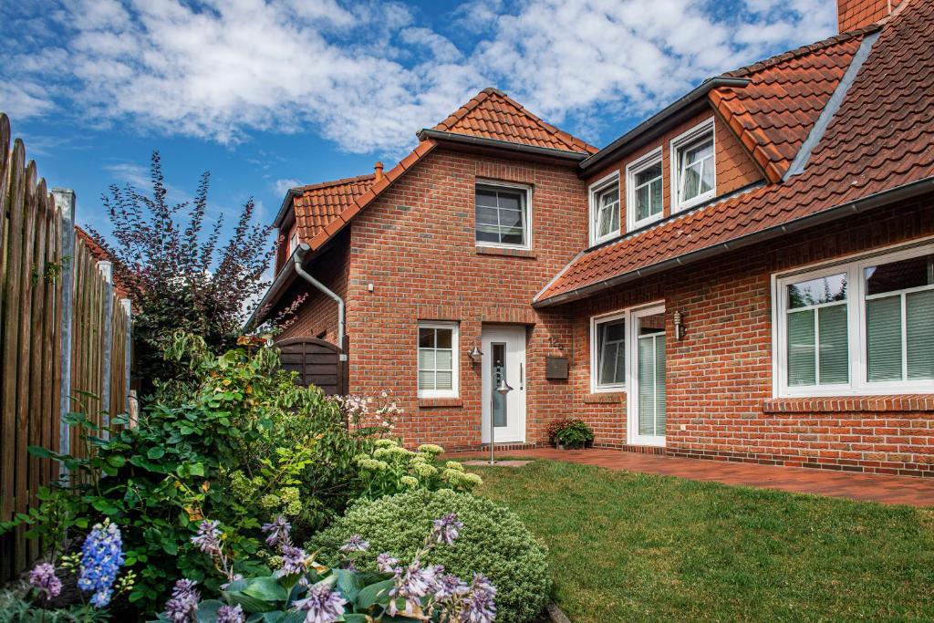 ein Backsteinhaus mit Garten davor in der Unterkunft Ferienwohnung Reddemann in Westerstede