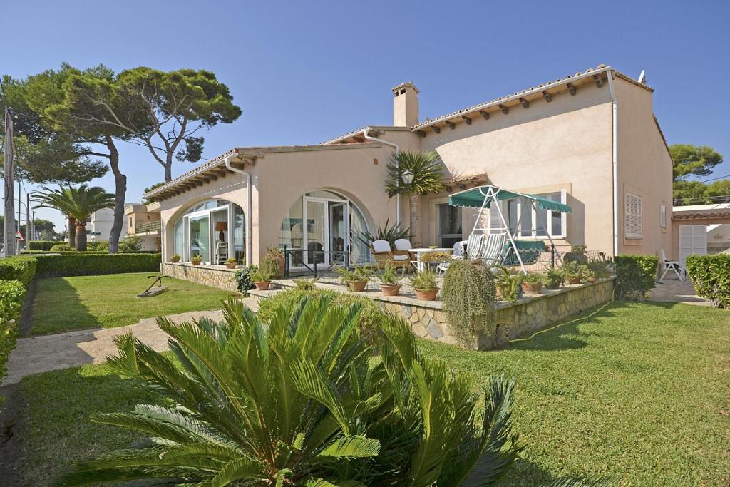 una casa con un cortile con palme di Villa Xata a Port de Pollença