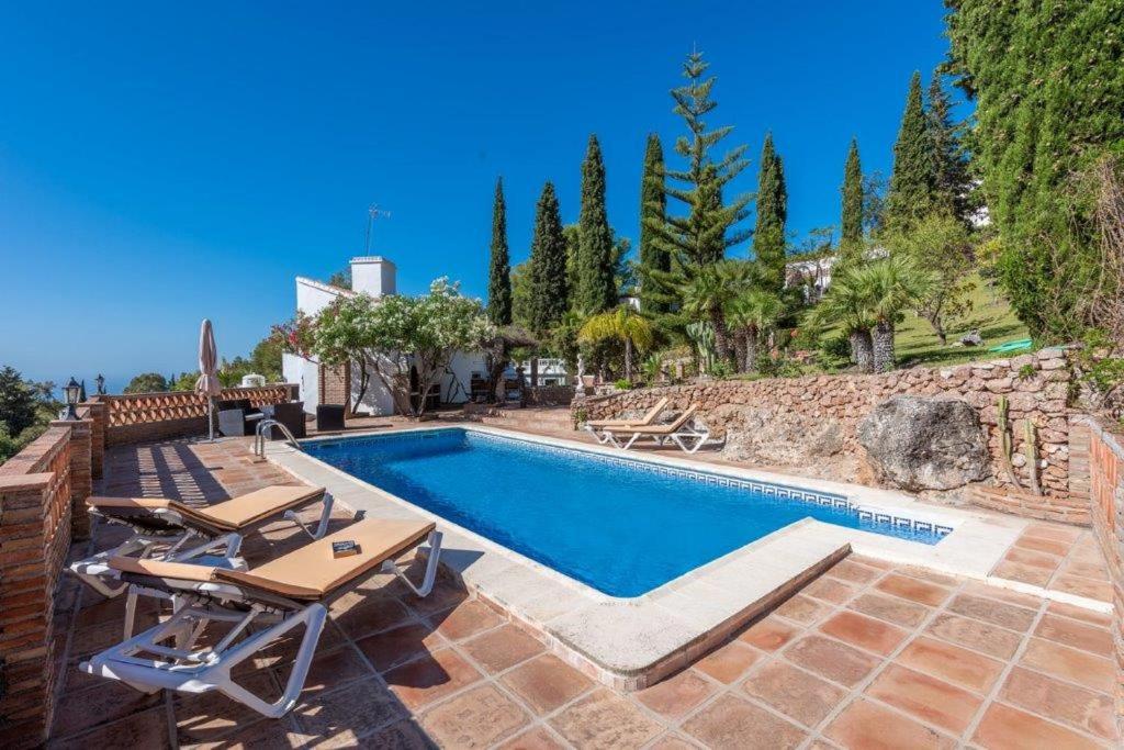 - une piscine avec une table et des chaises à côté d'une maison dans l'établissement Villa Hazilla SpainSunRentals 1132, à Frigiliana
