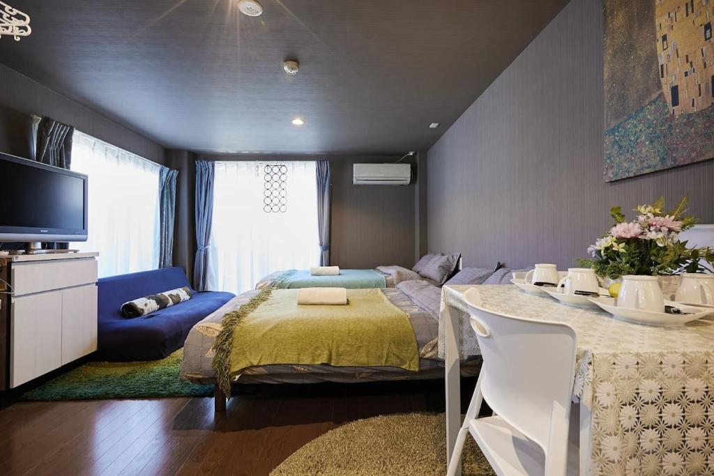 1 dormitorio con cama, mesa y TV en Akabane TK Building 101, en Tokio