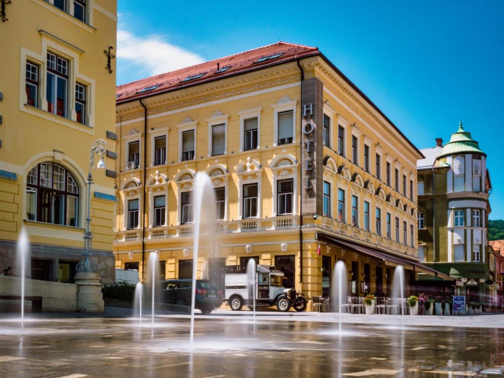 un edificio con una fontana di fronte di Hotel Evropa a Celje