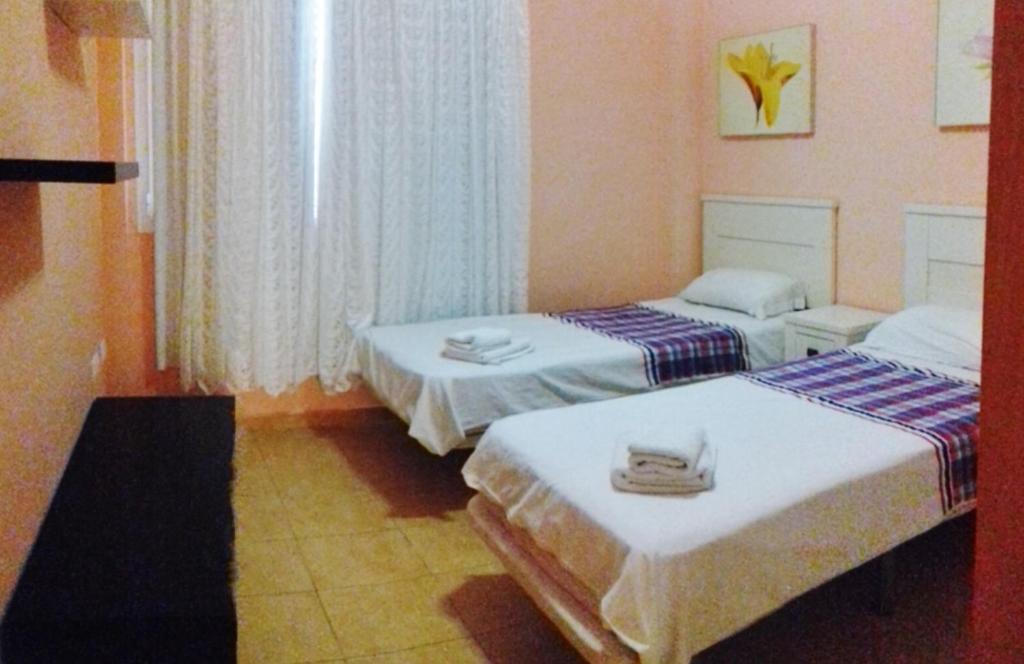 een kamer met twee bedden en een raam bij Playa Mogan Golden Beach 1 by El Sirocco in Puerto de Mogán