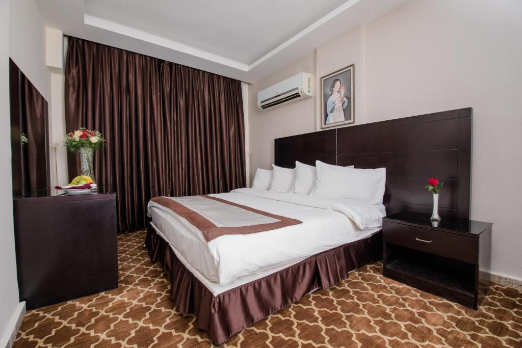 a bedroom with a large bed in a hotel room at Andalus Hotel in Baghdād