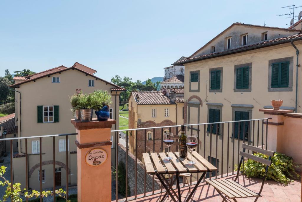 een balkon met een tafel en stoelen en gebouwen bij TERRAZZA COCCODE' spazioso con vista mozzafiato! in Lucca