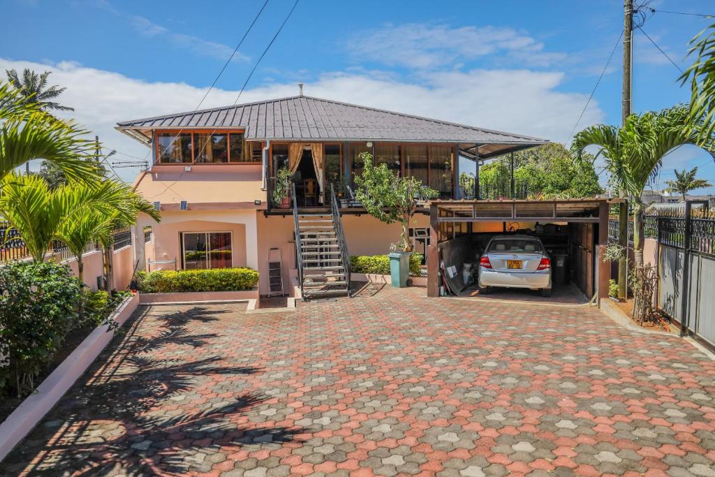 a house with a car parked in the driveway at Résidence An&Sy - Loft à Surinam in Surinam