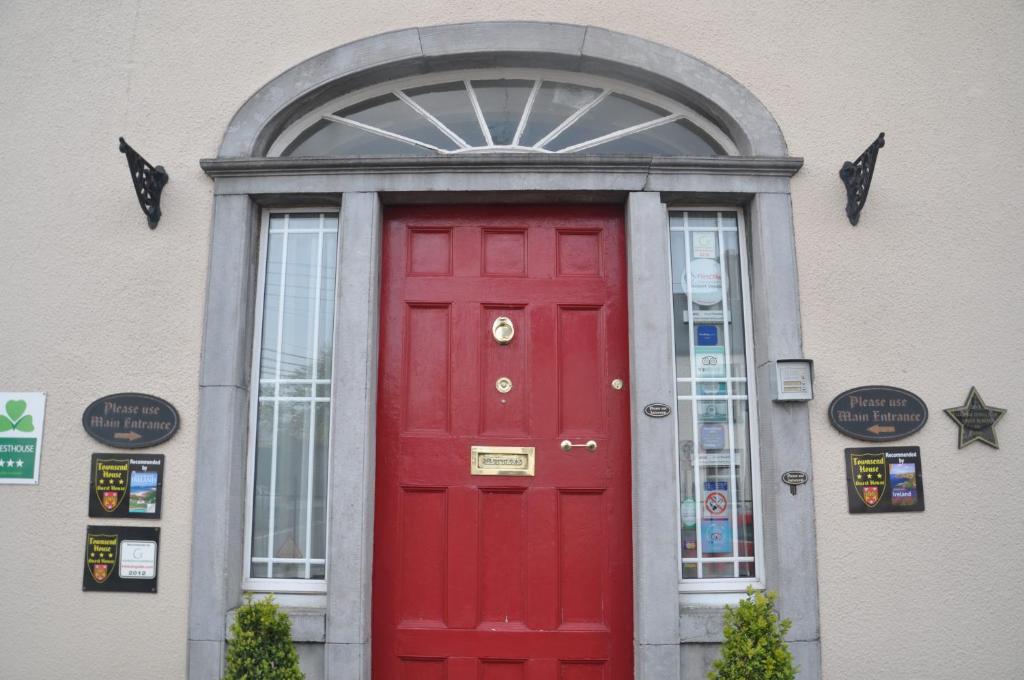 a red door on a building with a window at Townsend House Guest House in Birr