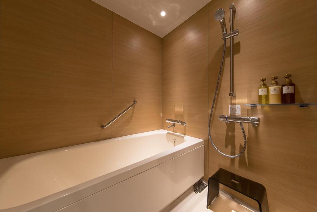 a bathroom with a bath tub and a shower at JR Kyushu Hotel Blossom Shinjuku in Tokyo