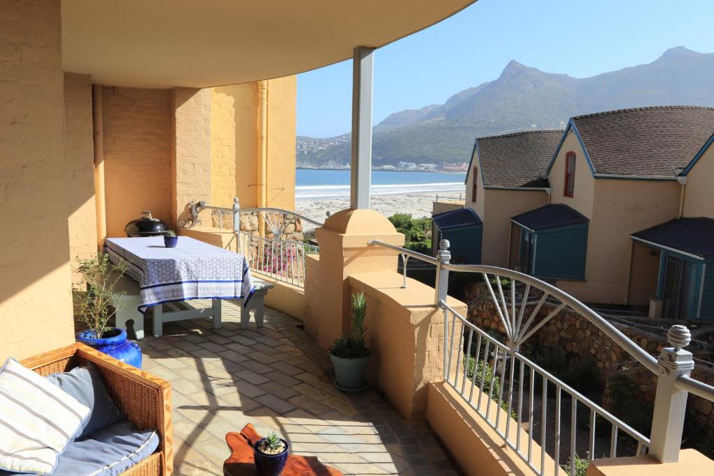 a balcony with a table and a view of the beach at 29 The Village in Hout Bay