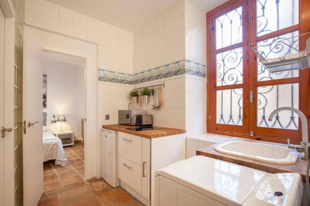 een keuken met een wastafel, een bad en een raam bij Apartamento Horno in Valencia