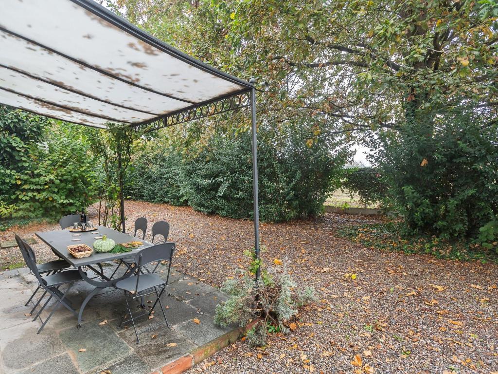 einen Tisch und Stühle unter einem Baldachin im Garten in der Unterkunft Belvilla by OYO La Villetta in Stagno Lombardo