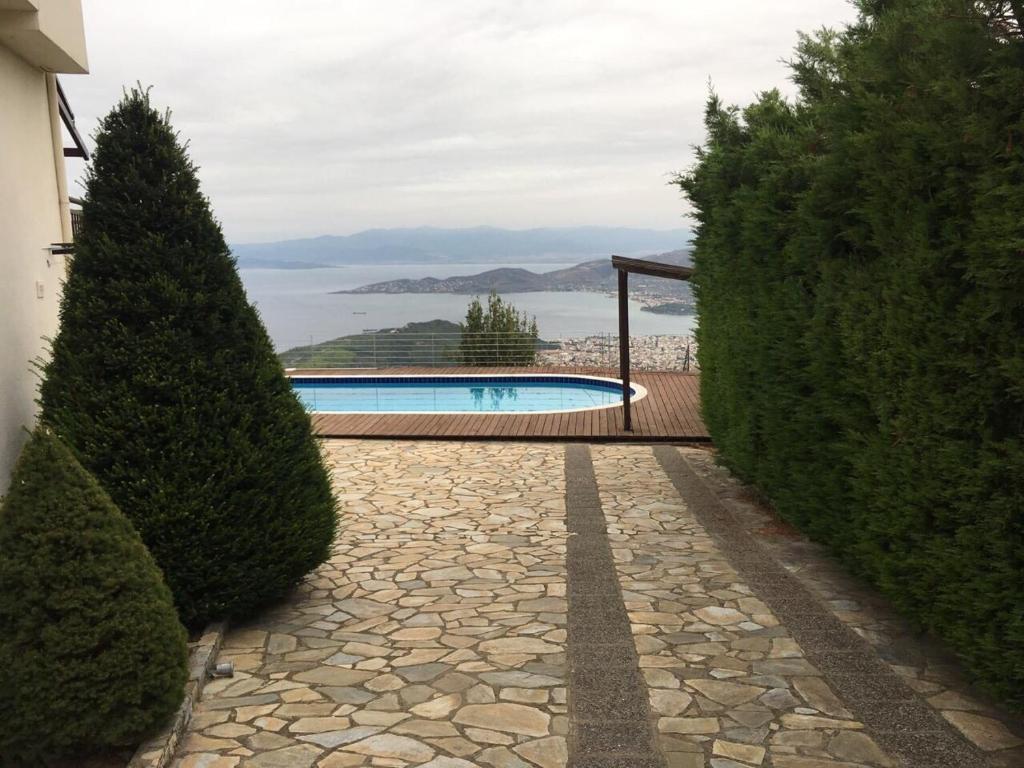 una pasarela de piedra que conduce a una piscina en una casa en Villa Dreamcatcher, en Katochori