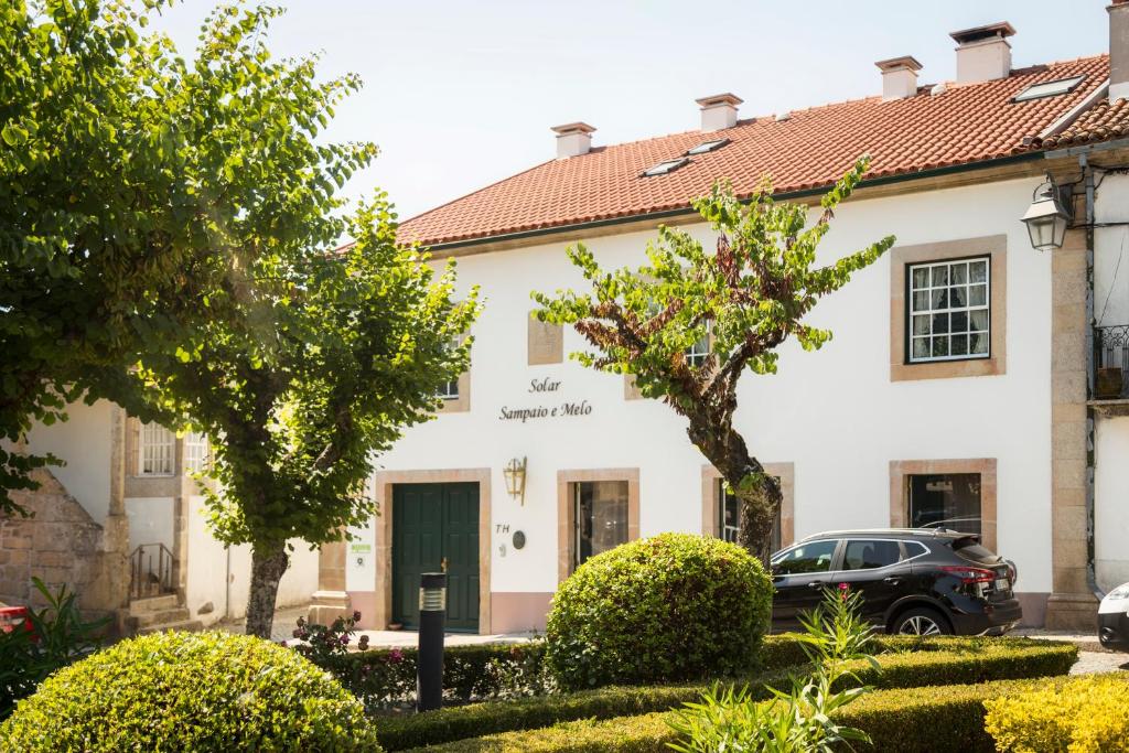 um edifício com um carro estacionado em frente em Solar Sampaio e Melo em Trancoso