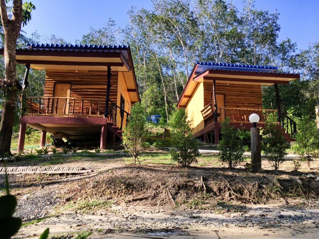 a house with a wrap around porch and a deck at Baan Panseng Bungalow in Ko Kood