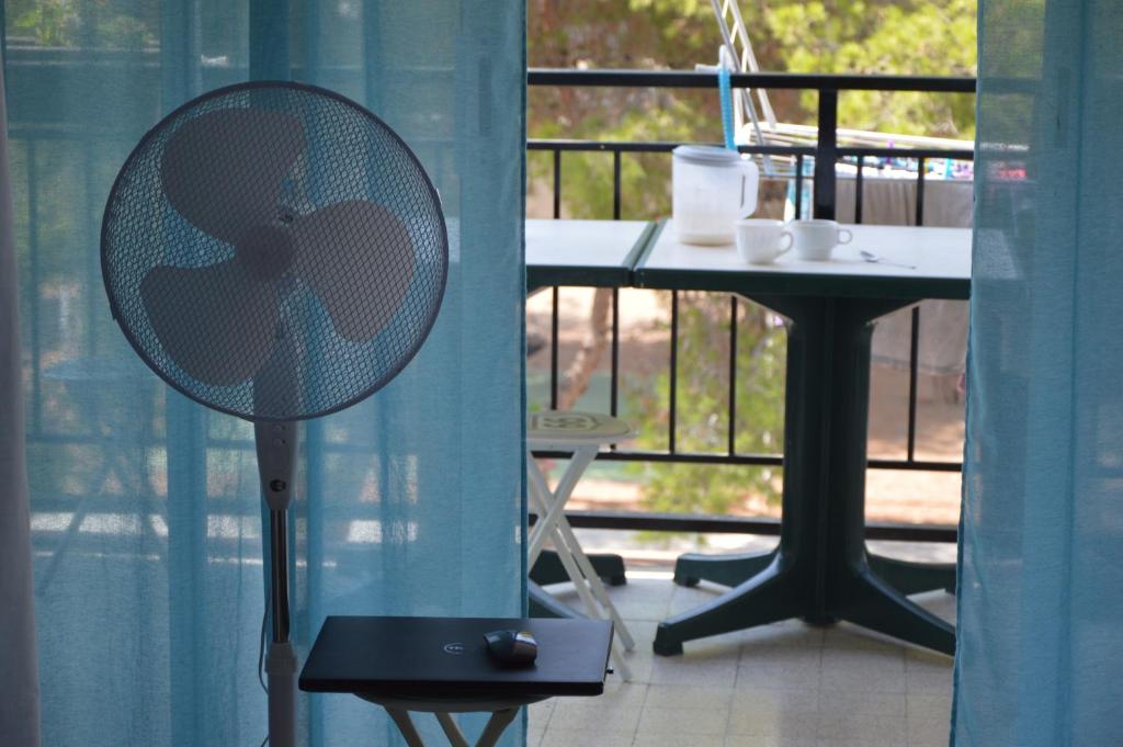 un ventilador sentado junto a una mesa en un balcón en Habitaciónes en apartamento en Salou