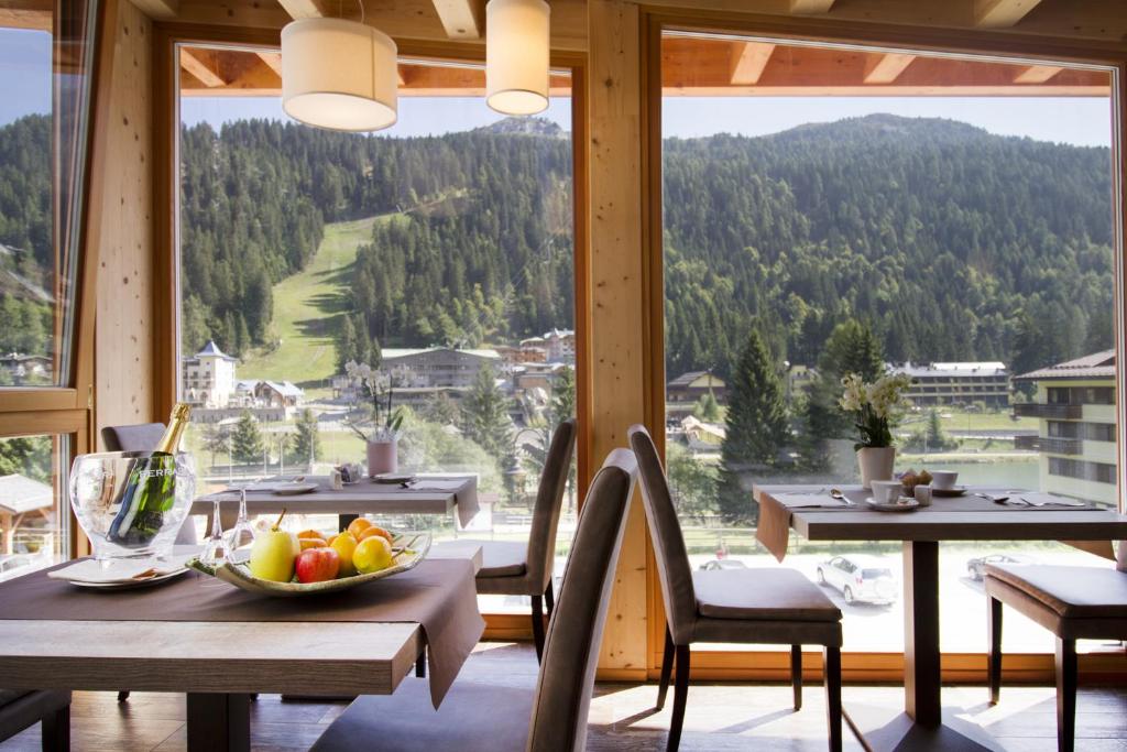 a table with a bowl of fruit in a room with a view at Hotel Garnì Caminetto in Madonna di Campiglio