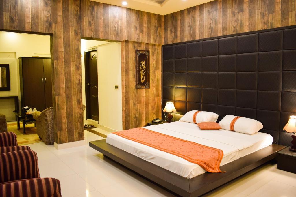 a bedroom with a large bed in a room at Royal Inn Hotel in Karachi