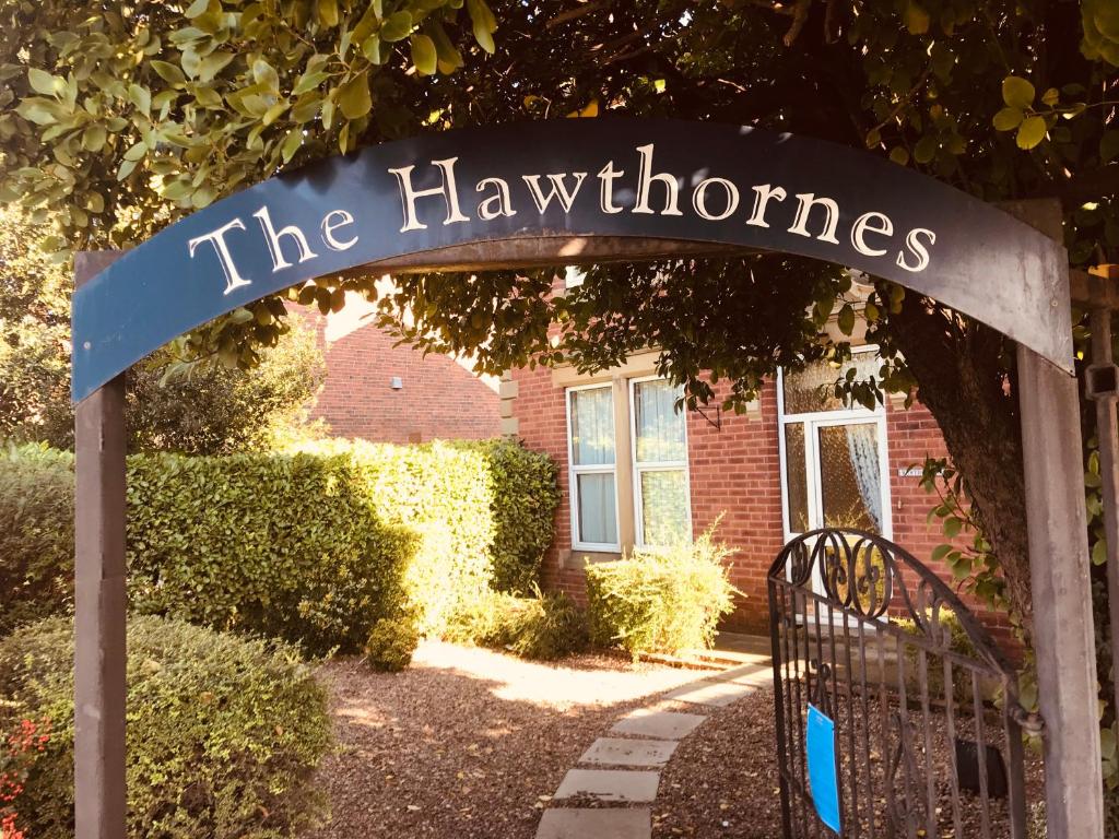 um sinal que diz os espinheiros em frente a um edifício em The Hawthornes Licensed Guest House em Knottingly