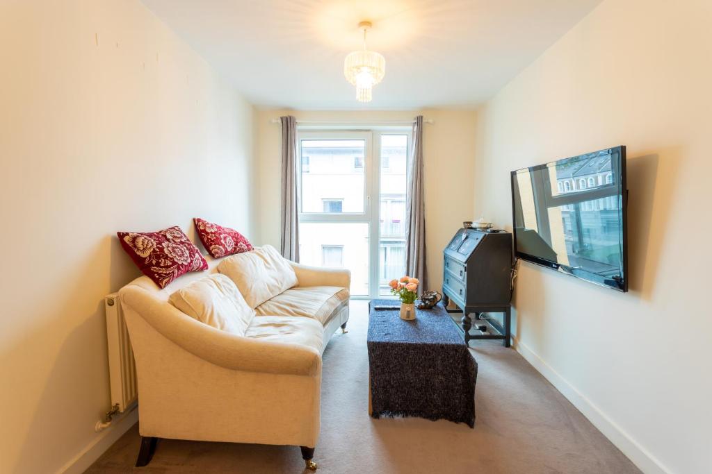 een woonkamer met een bank en een tv bij Amazing Modern 2 Bedroom Flat in Greenwich for 4 people in Londen