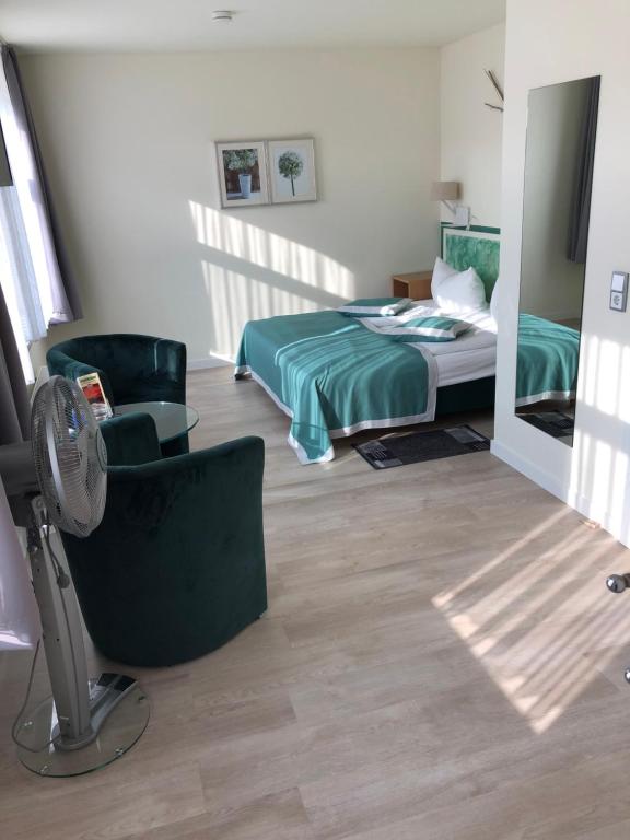- une chambre avec un lit, des chaises et un ventilateur dans l'établissement An der Porzellan-Manufaktur Pension, à Meissen
